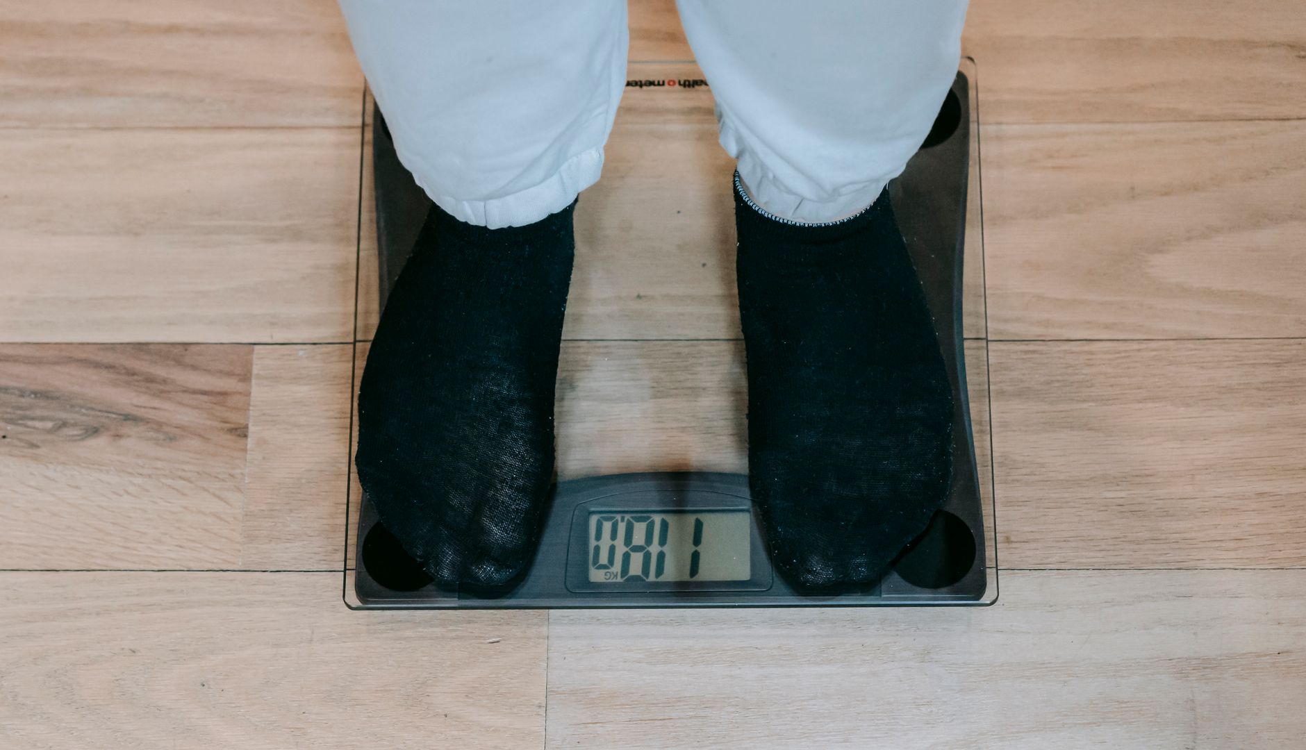 Person stepping on weighing scale to check body weight and health