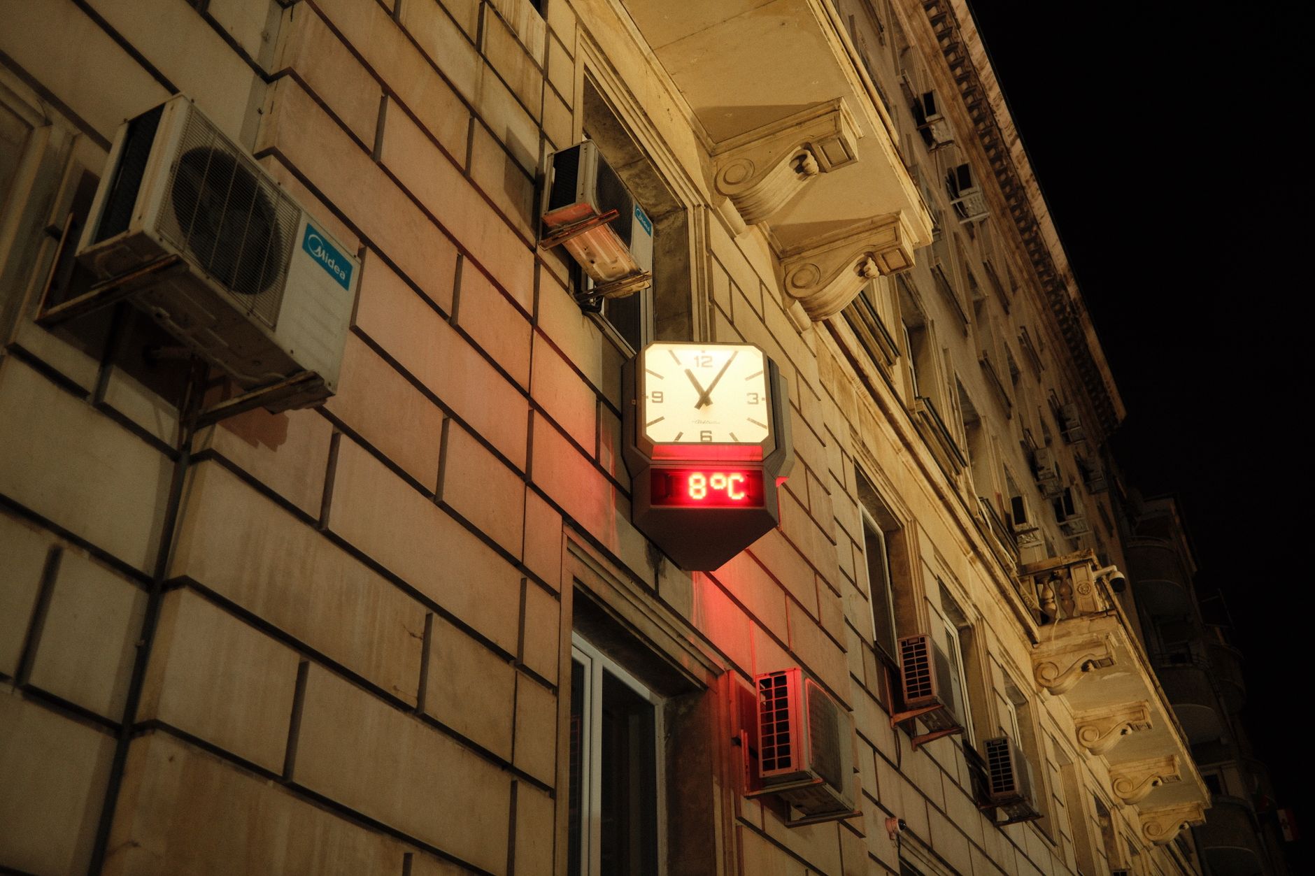 Outdoor thermometer in summer city showing high temperature reading