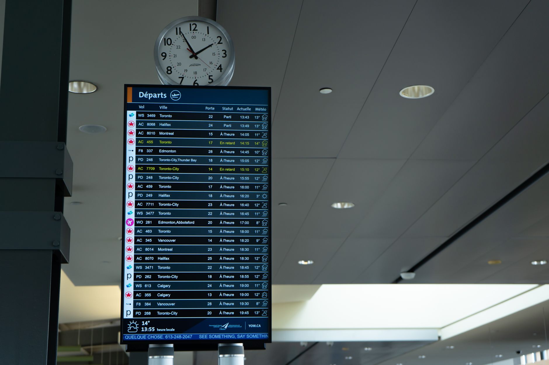 Airport departure board showing flight times and clocks