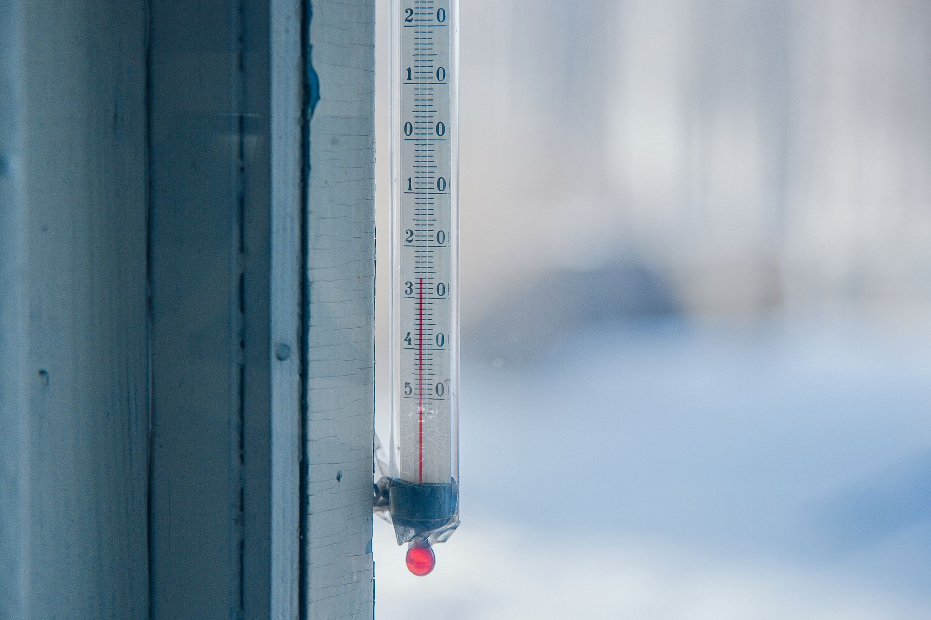 Frost-covered outdoor thermometer showing sub-zero winter temperature