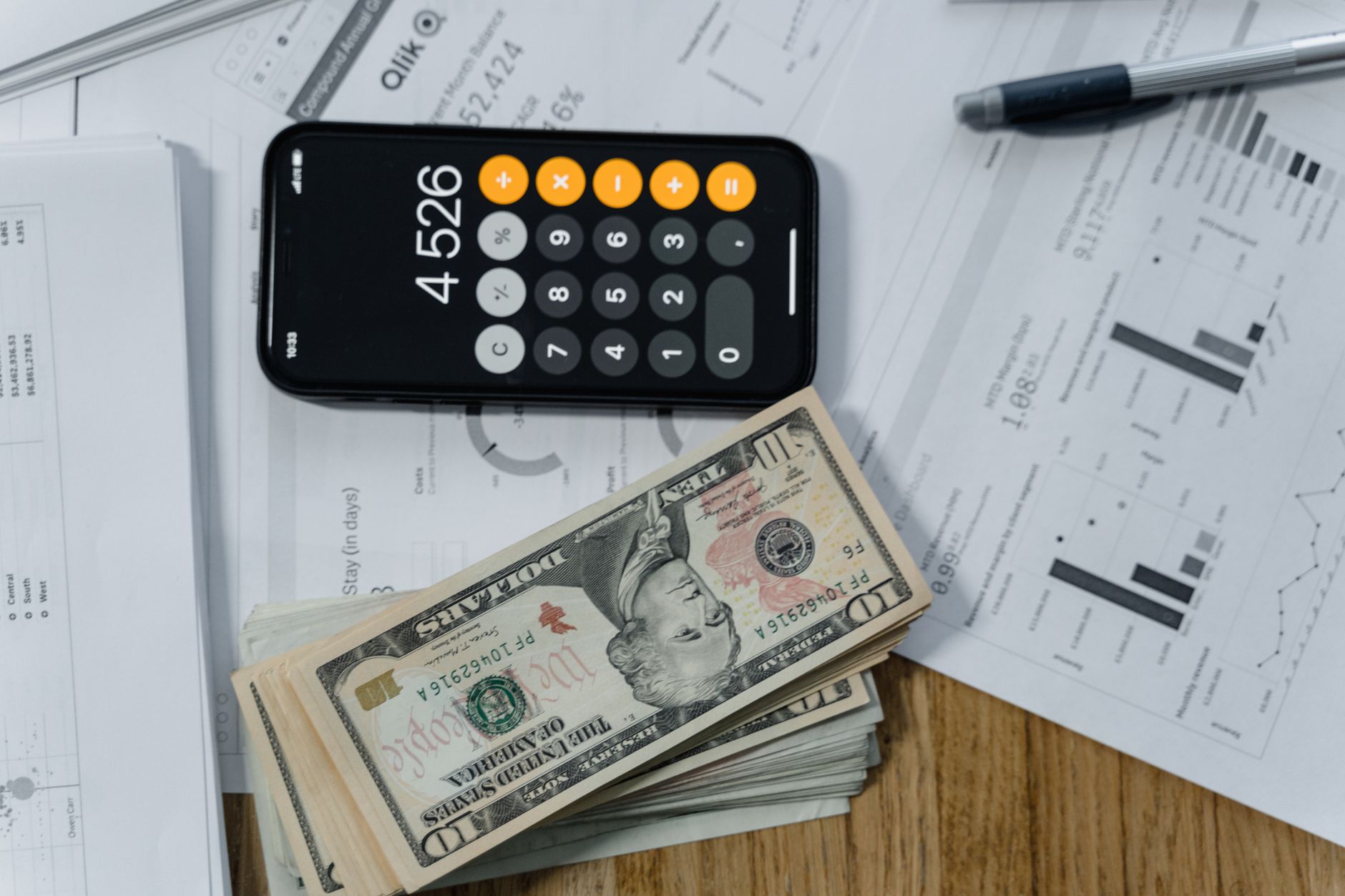 Stack of bills and a calculator used for budgeting debt payoff