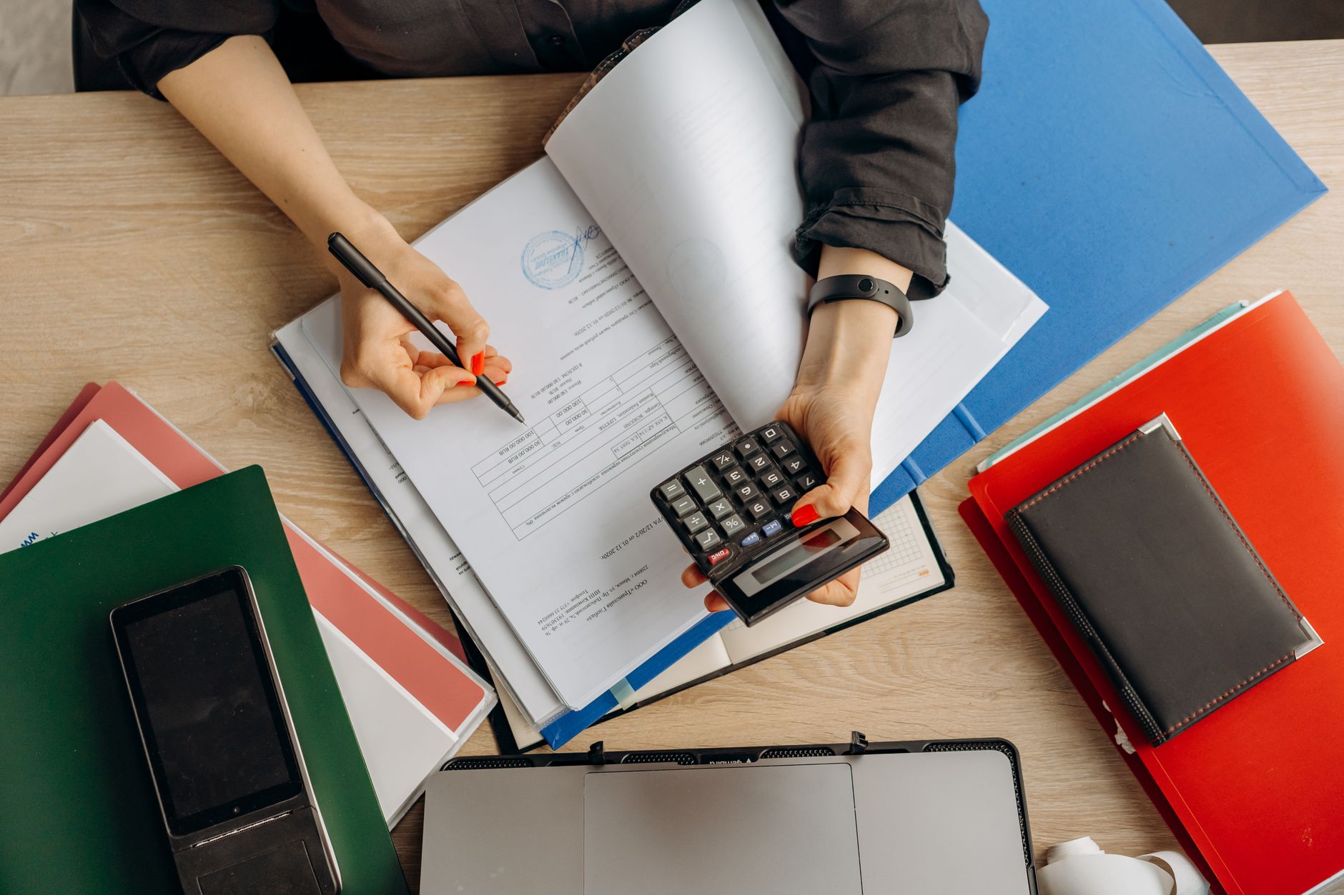Person reviewing household budget and savings on a laptop with a calculator