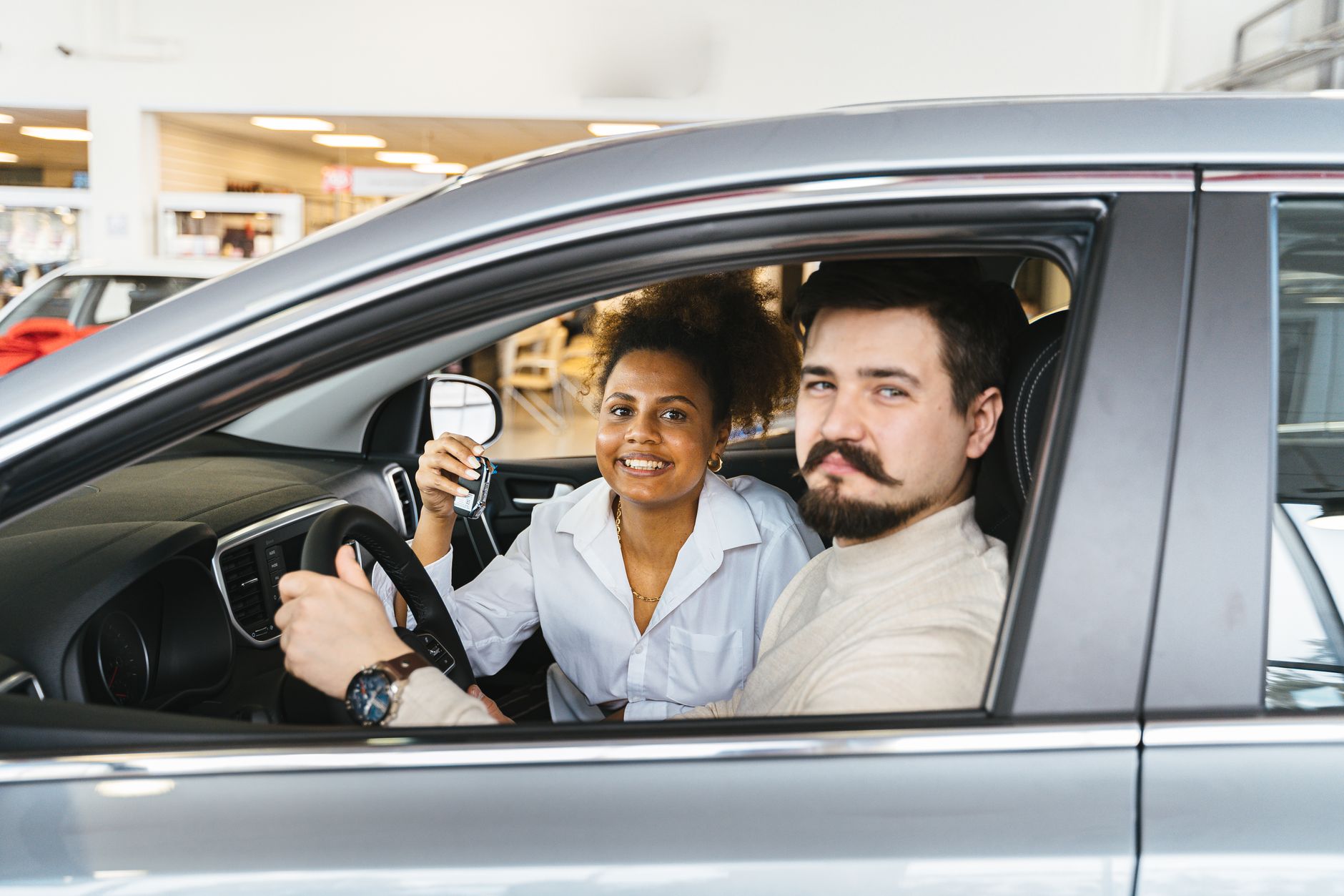 Couple test driving a new car at a dealership