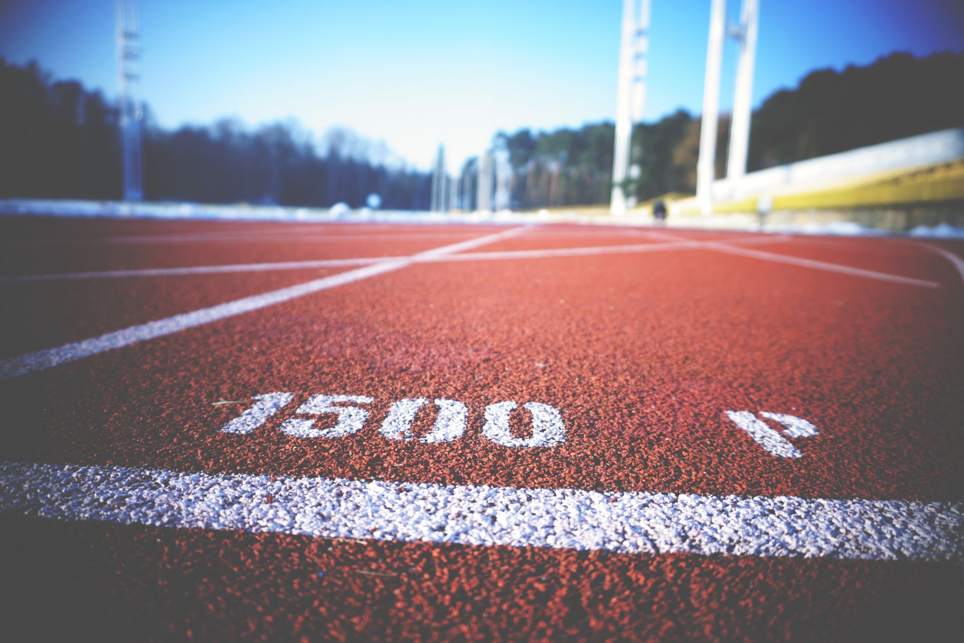 Runner checking pace on a track with a stopwatch