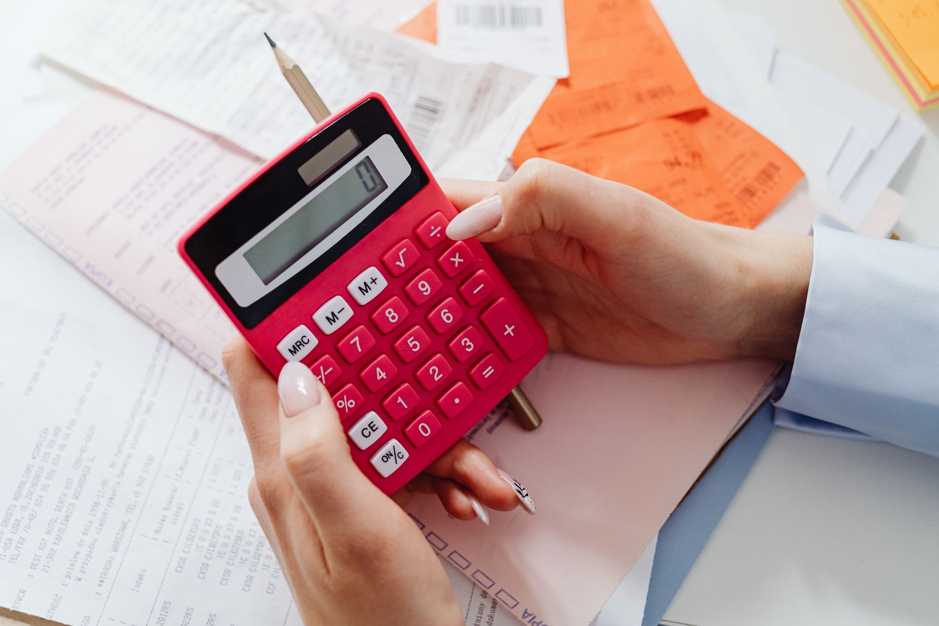 House model with calculator and pen on a desk showing refinance planning