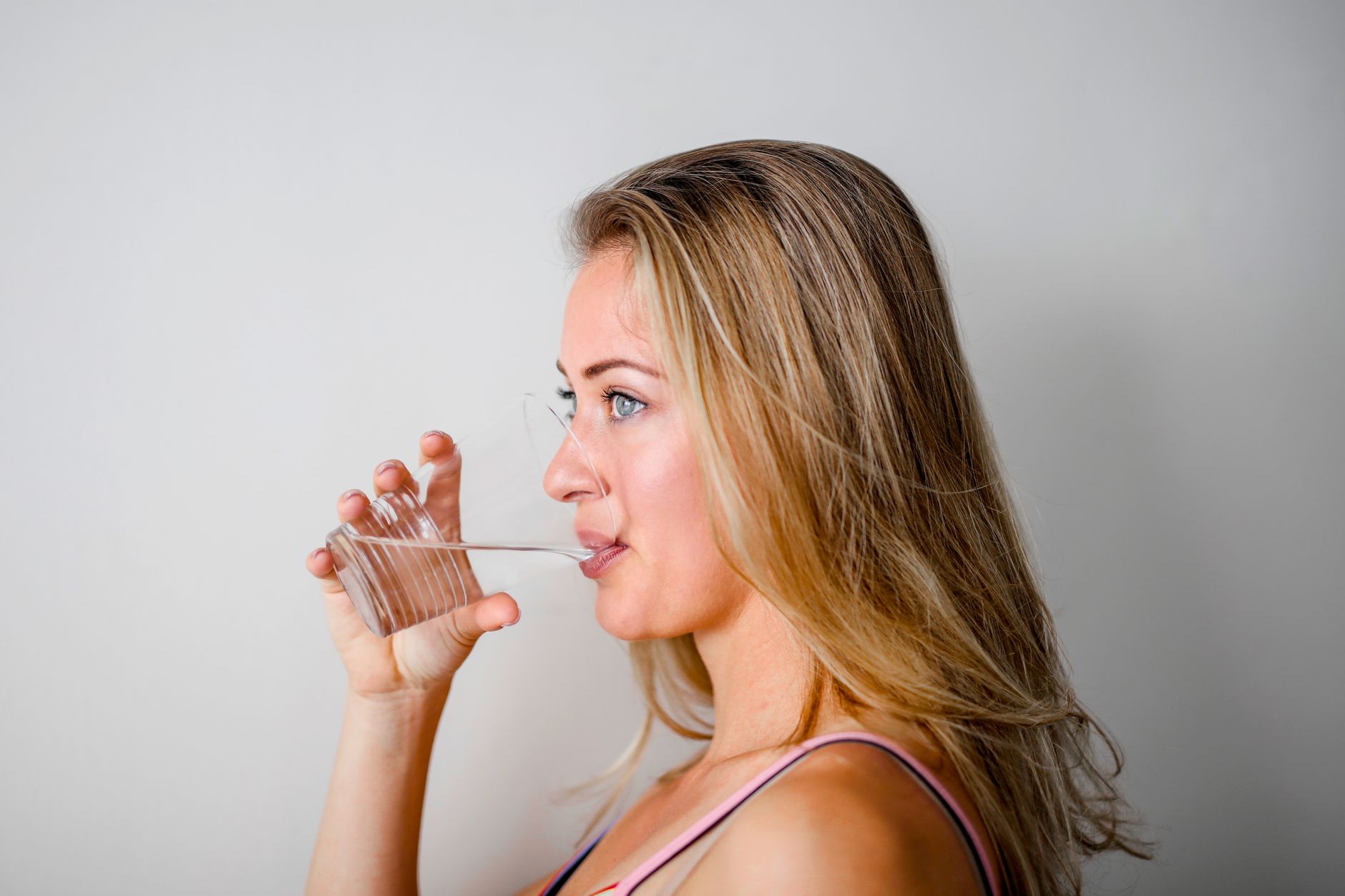 Person drinking a glass of water for daily hydration