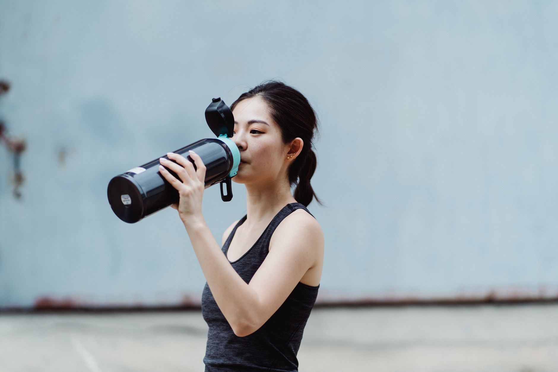Woman drinking water from a sports bottle during exercise