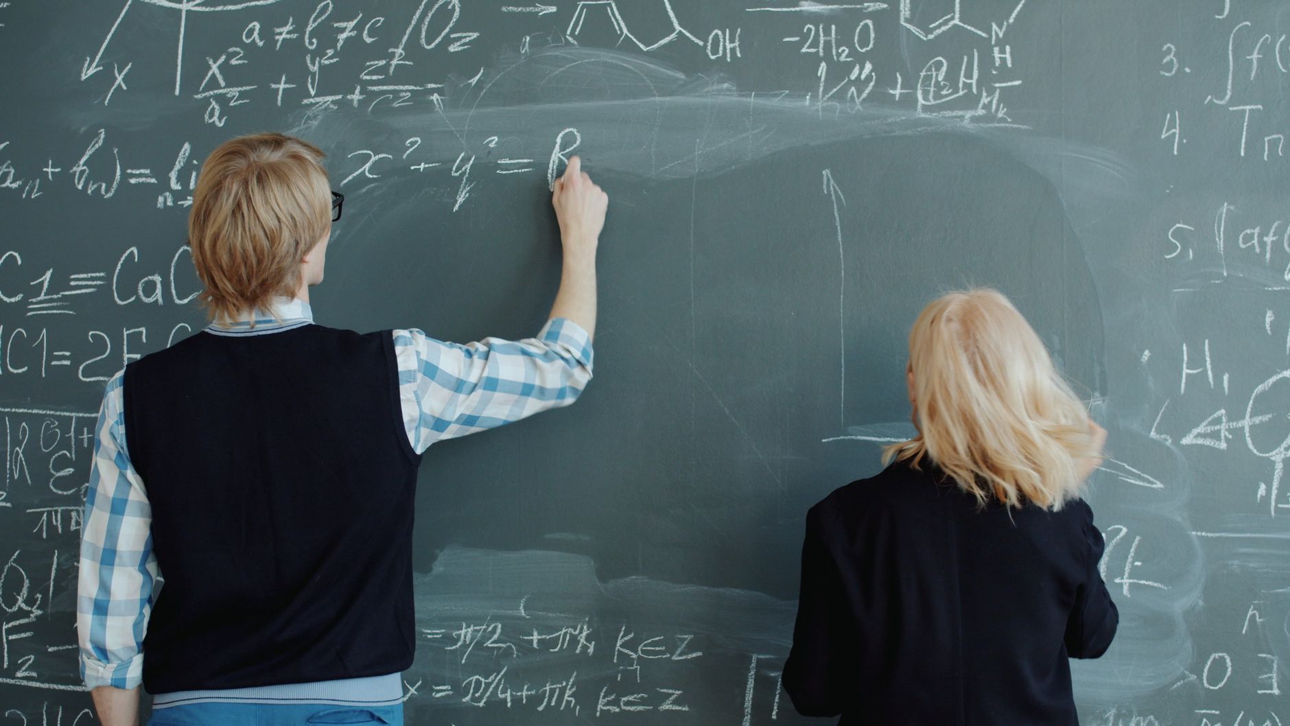 Students solving a math problem on a classroom whiteboard