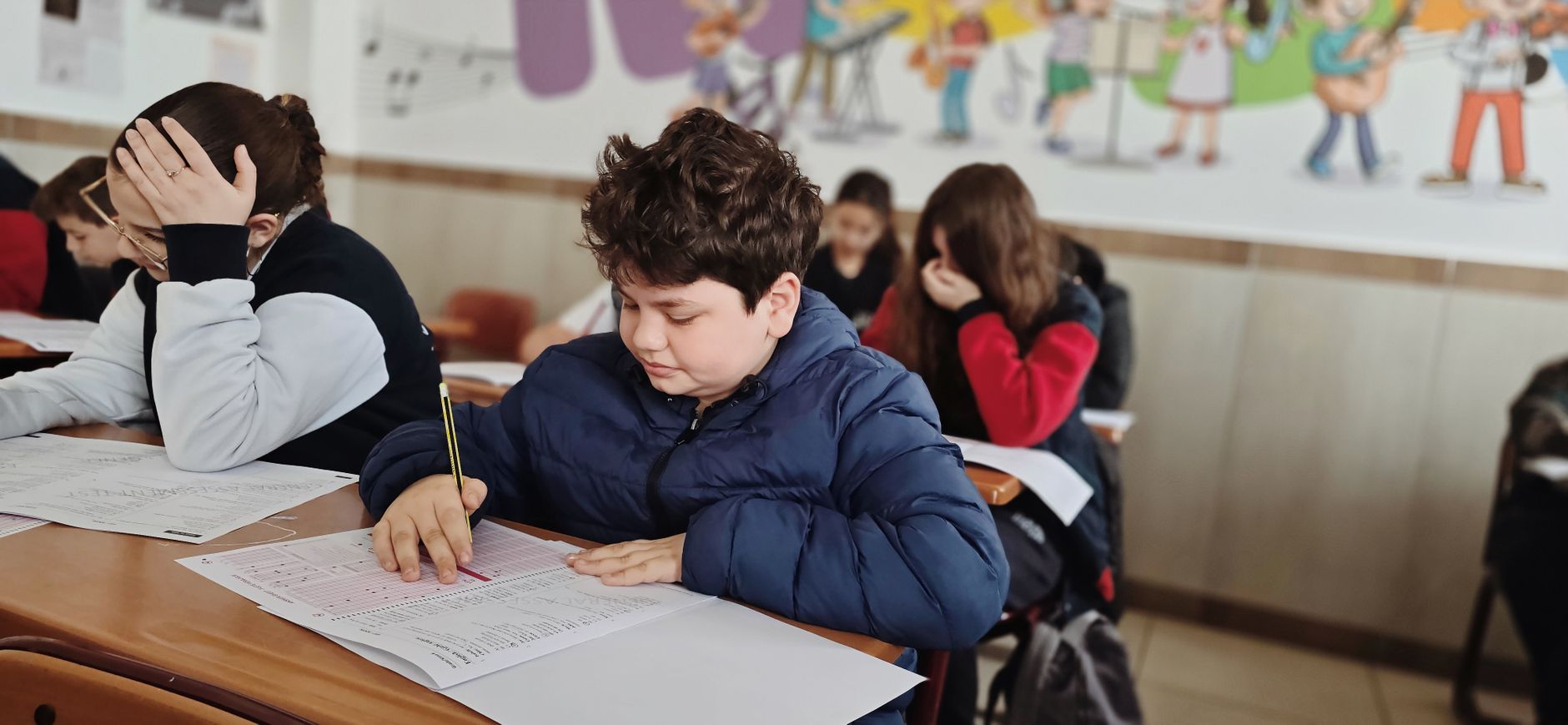 Student writing an exam in a classroom